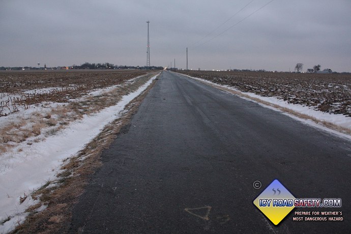 Invisible black ice completely covers a road.